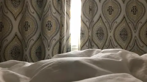 Salón pequeño con estores blancos translúcidos que dejan pasar la luz
