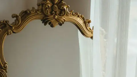 Baño pequeño con un gran espejo redondo retroiluminado